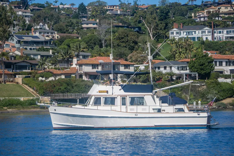 Dauntless Yacht Photos Pics 1995 Grand Banks 42 Classic yacht cruising near scenic coastal homes.