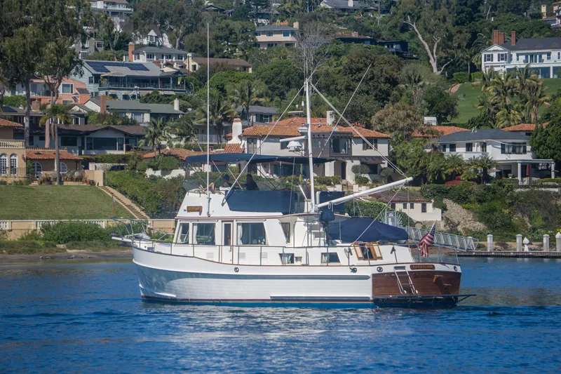 Dauntless Yacht Photos Pics 1995 Grand Banks 42 Classic yacht cruising near waterfront homes.