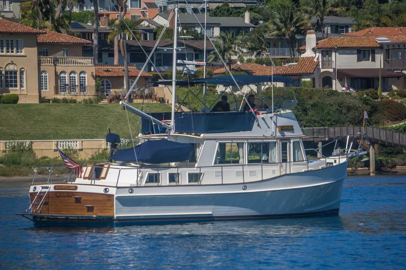 Dauntless Yacht Photos Pics 1995 Grand Banks 42 Classic yacht cruising near waterfront homes.