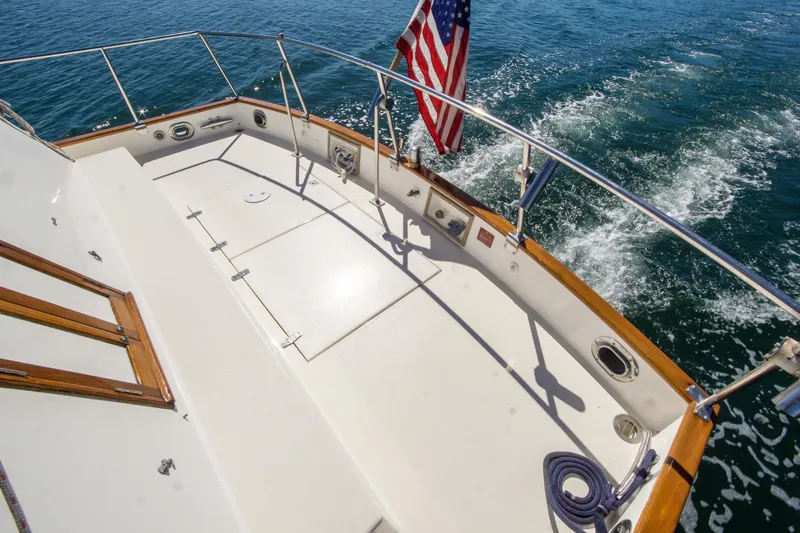Dauntless Yacht Photos Pics 1995 Grand Banks 42 Classic yacht deck with American flag, cruising on open water.