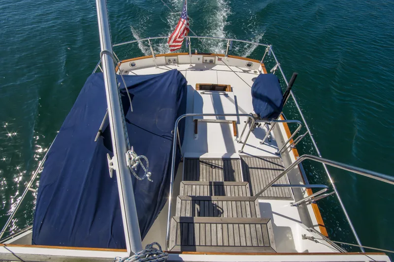Dauntless Yacht Photos Pics Grand Banks 42 Classic yacht deck, 1995 model, cruising on clear blue water.