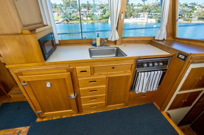 Dauntless Yacht Photos Pics 1995 Grand Banks 42 Classic yacht kitchen with wooden cabinetry and scenic water view.