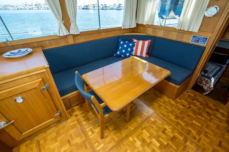 Dauntless Yacht Photos Pics Interior of 1995 Grand Banks 42 Classic yacht with wooden table and blue seating.