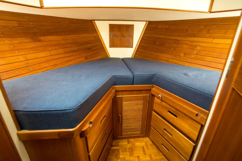 Dauntless Yacht Photos Pics 1995 Grand Banks 42 Classic cabin interior with wooden paneling and blue cushions.