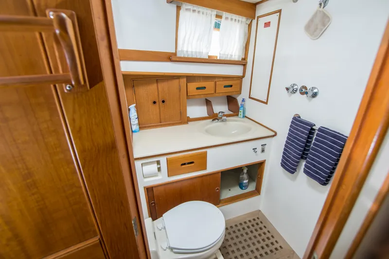Dauntless Yacht Photos Pics Bathroom interior of 1995 Grand Banks 42 Classic yacht, featuring wood cabinetry and nautical decor.