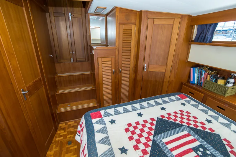 Dauntless Yacht Photos Pics Cozy cabin interior of 1995 Grand Banks 42 Classic with wooden furnishings and quilted bedspread.