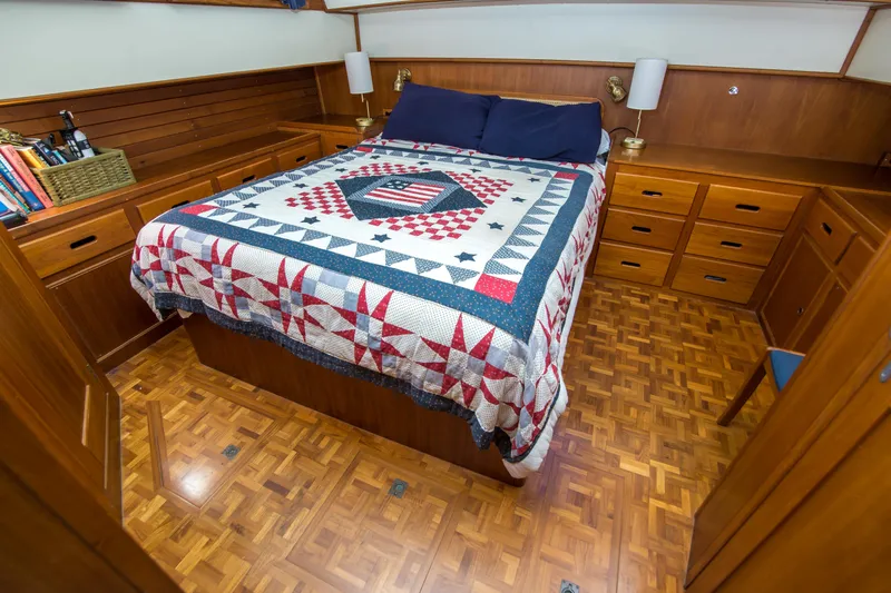 Dauntless Yacht Photos Pics Cozy bedroom in 1995 Grand Banks 42 Classic yacht with quilted bedspread and wooden cabinetry.