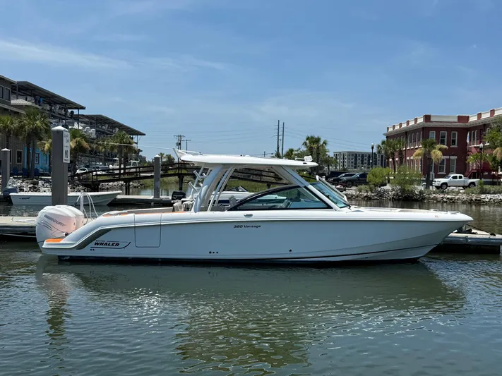  Yacht Photos Pics 2019 Boston Whaler 320 Vantage boat docked in a marina under clear skies.