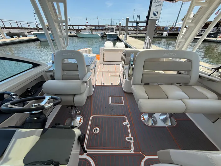  Yacht Photos Pics 2019 Boston Whaler 320 Vantage interior with seating and steering wheel at marina dock.
