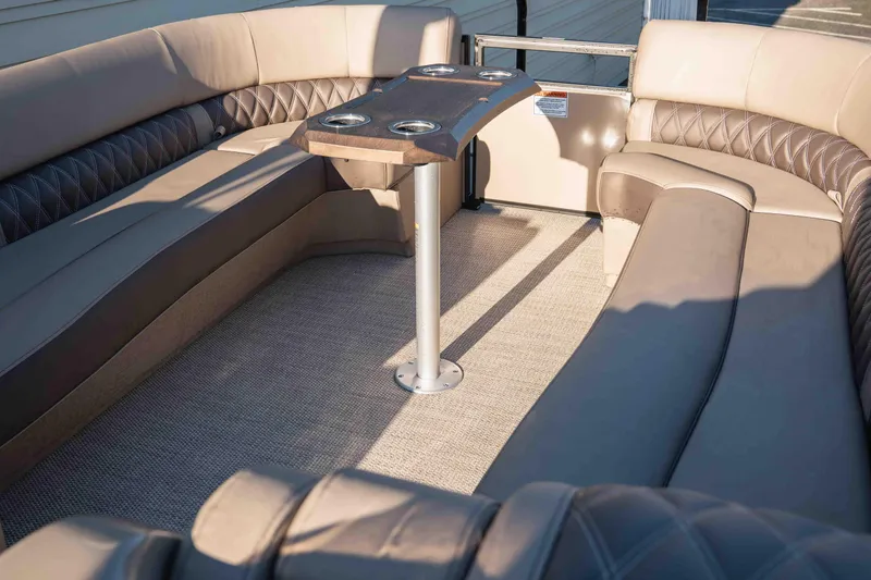  Yacht Photos Pics Luxurious seating area on 2023 Bennington R25 FBAST pontoon boat with table and cup holders.