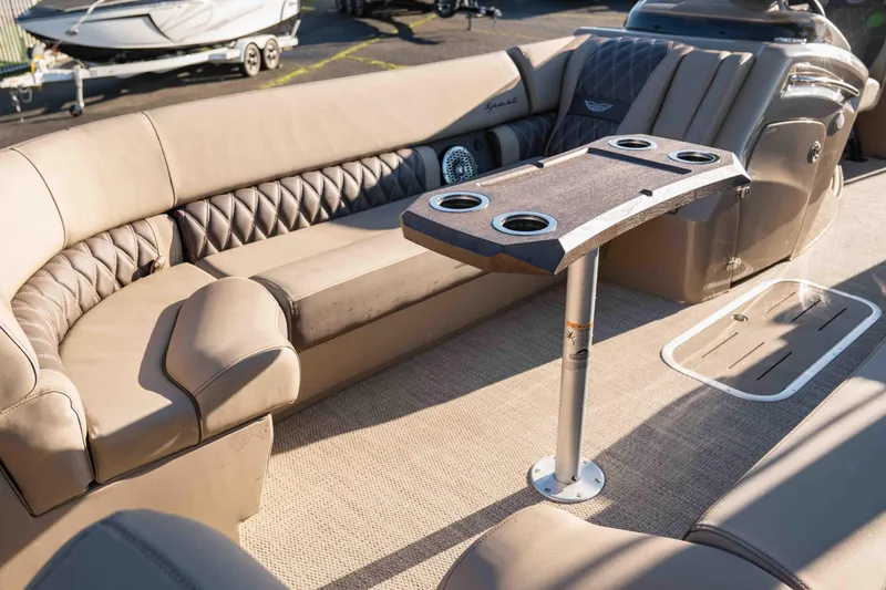  Yacht Photos Pics Luxurious interior of 2023 Bennington R25 FBAST pontoon boat with plush seating and table.