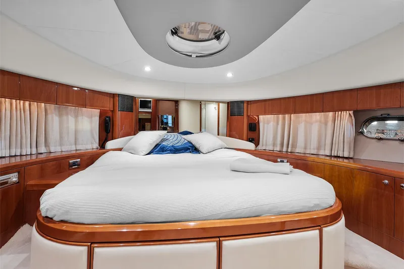  Yacht Photos Pics Luxurious bedroom interior of 2003 Princess 23m yacht with elegant wood paneling.