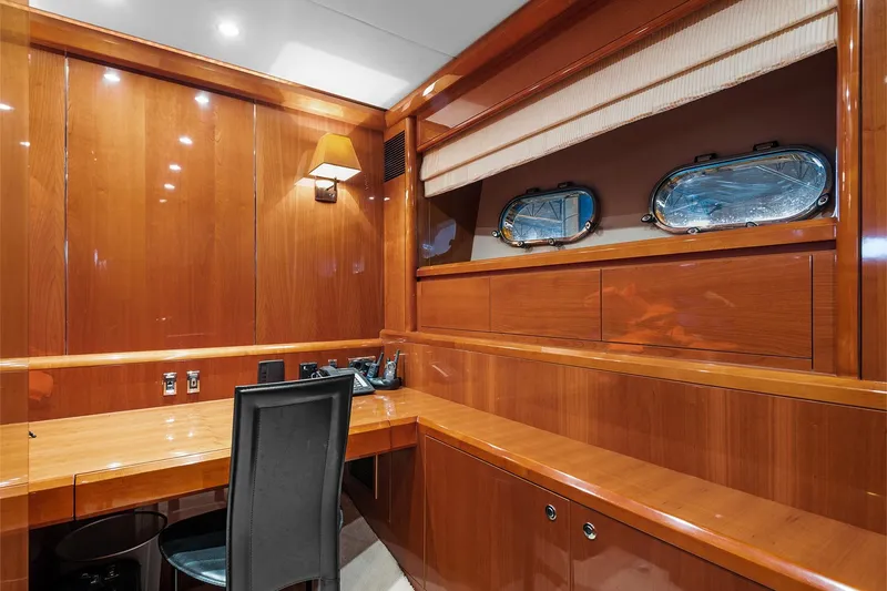 Yacht Photos Pics Luxurious wooden interior of a 2003 Princess 23m yacht with desk and portholes.