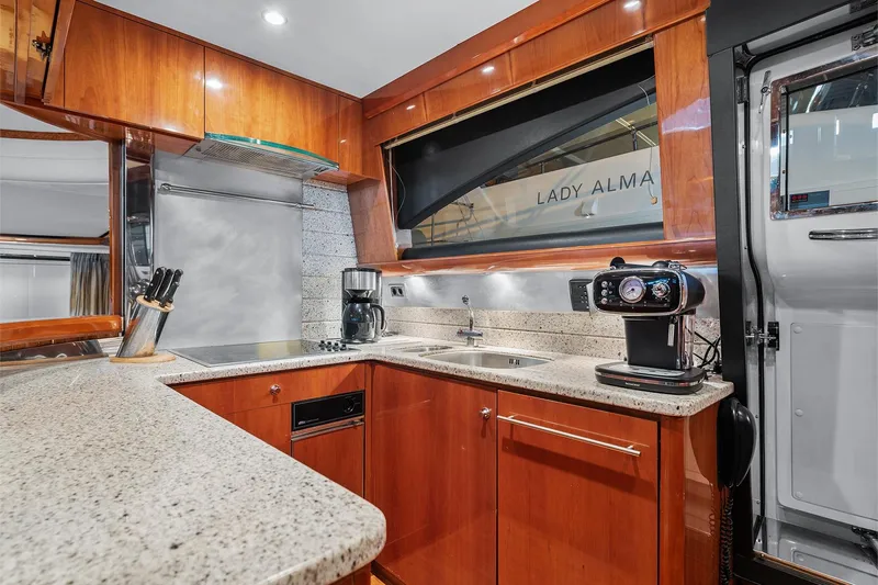  Yacht Photos Pics Luxurious yacht kitchen interior with modern appliances, featuring wood cabinetry and granite countertops, 2003 Princess 23m.