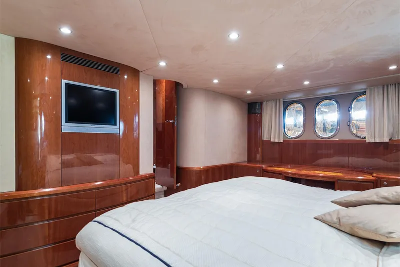  Yacht Photos Pics Luxurious 2003 Princess 23m yacht bedroom with wood paneling and porthole windows.