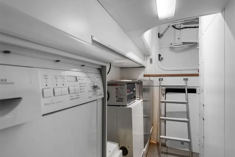  Yacht Photos Pics Laundry area inside 2003 Princess 23m yacht with appliances and ladder access.