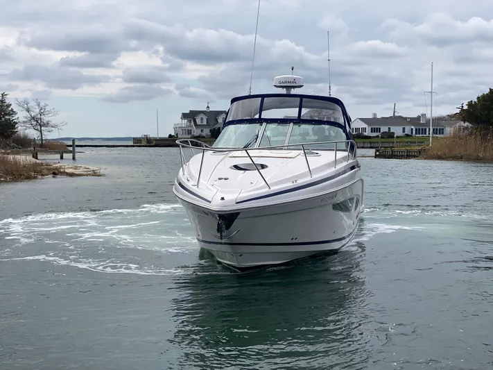  Yacht Photos Pics 2015 Regal 32 Express boat navigating a calm waterway near coastal homes.