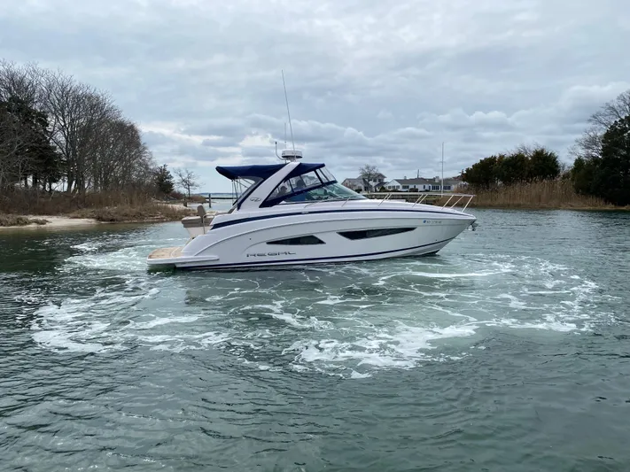  Yacht Photos Pics 2015 Regal 32 Express boat cruising on a calm waterway under cloudy skies.