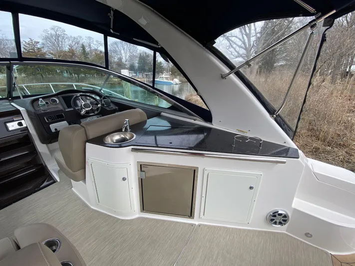  Yacht Photos Pics 2015 Regal 32 Express boat interior with helm, seating, and kitchenette area.