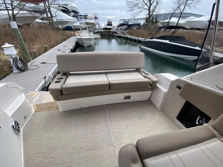  Yacht Photos Pics 2015 Regal 32 Express boat interior with beige seating at a marina dock.