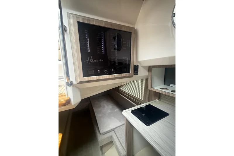  Yacht Photos Pics Interior of 2025 Hanover 447 boat with control panel and seating area.