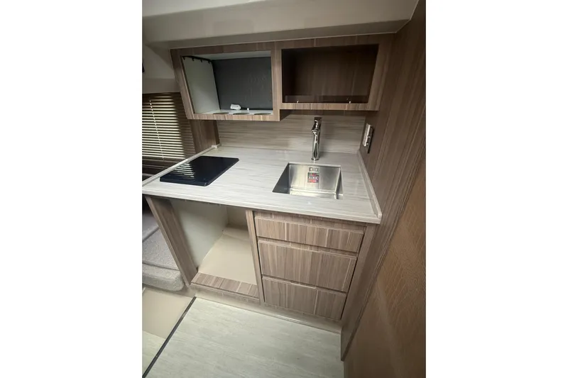  Yacht Photos Pics Compact kitchen area in a 2025 Hanover 447 RV with sink and stove.