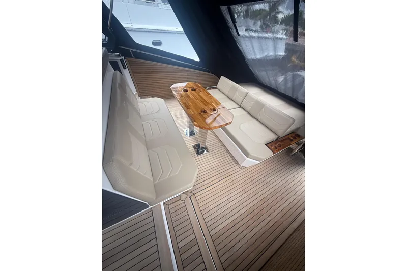  Yacht Photos Pics Luxurious interior of 2025 Hanover 447 yacht with beige seating and wooden table.