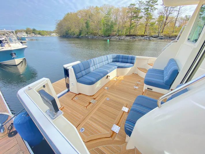 Persistence Yacht Photos Pics 2011 Sabre 40 Sedan yacht with spacious deck seating, docked by a scenic waterfront.