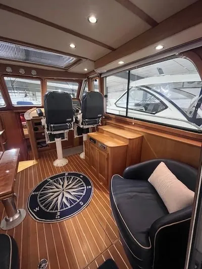 Persistence Yacht Photos Pics 2011 Sabre 40 Sedan interior with wood flooring, compass rug, and helm chairs.