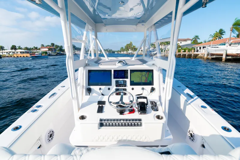 Freedom Frigate Yacht Photos Pics 2025 Invincible 36 Open Fisherman boat dashboard with navigation screens on a sunny day.