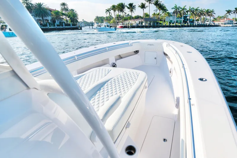 Freedom Frigate Yacht Photos Pics 2025 Invincible 36 Open Fisherman boat on a sunny waterfront with palm trees.