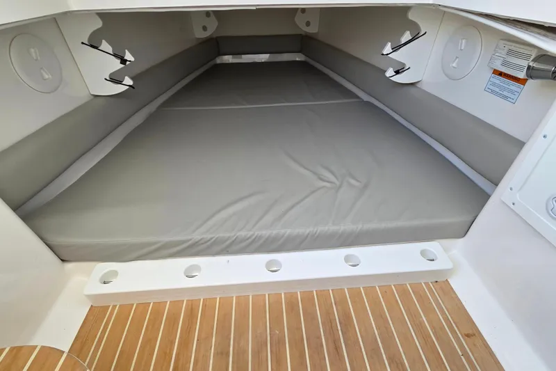 Three Ladies Yacht Photos Pics 2021 Regulator 34 boat cabin interior with cushioned seating and wood flooring.