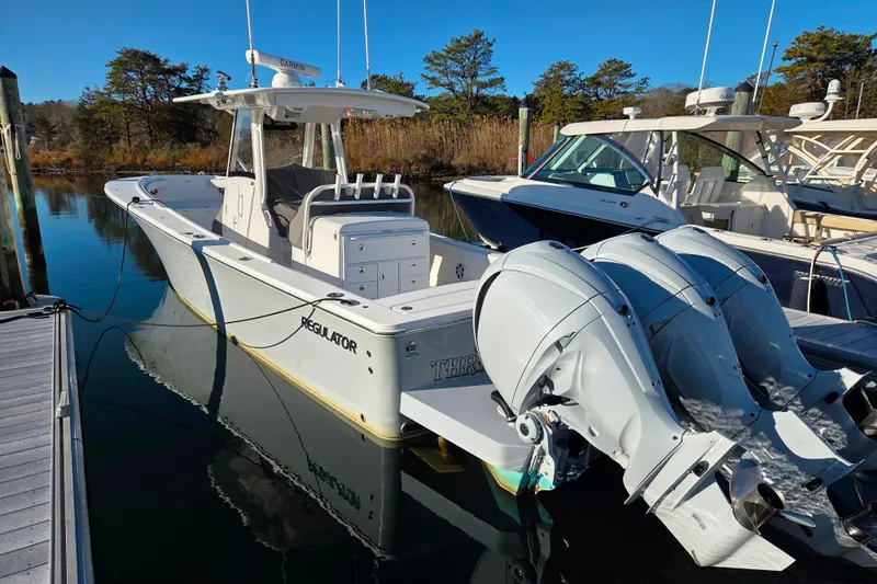 Three Ladies Yacht Photos Pics 2021 Regulator 34 boat docked with twin outboard engines, clear blue sky.
