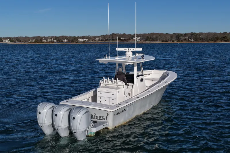 Three Ladies Yacht Photos Pics 2021 Regulator 34 boat with triple engines cruising on a calm lake.
