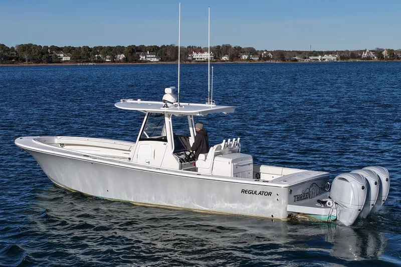 Three Ladies Yacht Photos Pics 2021 Regulator 34 boat on calm water with triple outboard engines.
