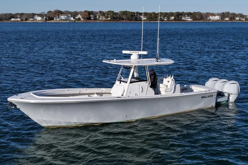 Three Ladies Yacht Photos Pics 2021 Regulator 34 boat on calm water, featuring triple outboard engines.