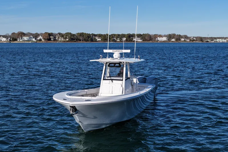 Three Ladies Yacht Photos Pics 2021 Regulator 34 boat cruising on a calm blue lake with shoreline houses.