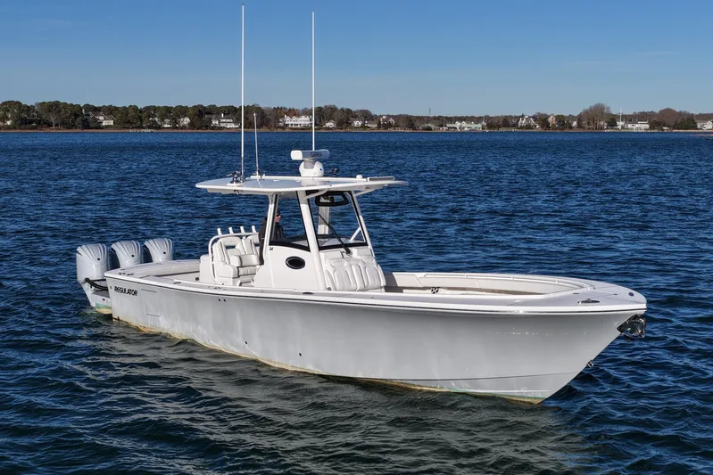 Three Ladies Yacht Photos Pics 2021 Regulator 34 boat on calm water, featuring triple outboard engines.