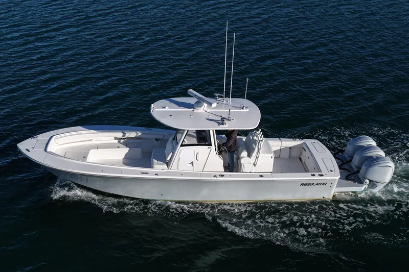 Three Ladies Yacht Photos Pics 2021 Regulator 34 boat cruising on open water, featuring triple outboard engines.