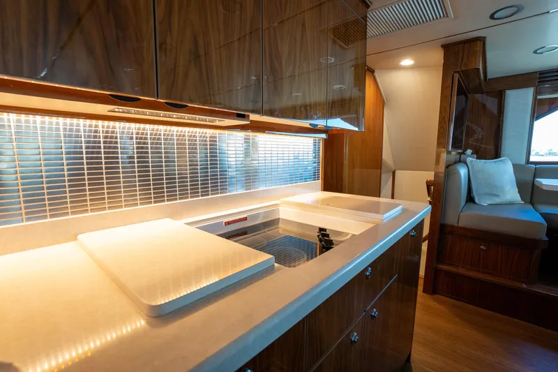 Galati Yacht Sales Trade Yacht Photos Pics Luxurious kitchen interior of 2021 Viking 72 Enclosed Bridge yacht with modern design.