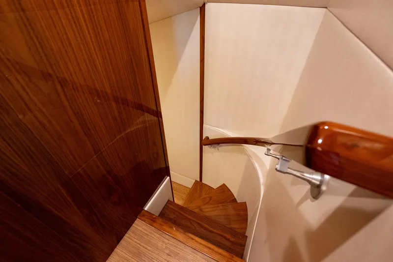 Galati Yacht Sales Trade Yacht Photos Pics Wooden staircase inside 2021 Viking 72 Enclosed Bridge yacht, featuring elegant handrail design.