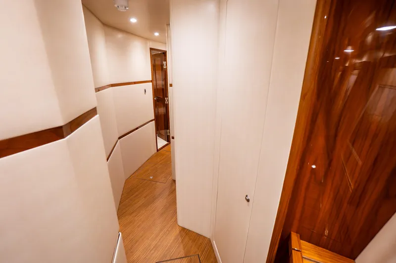 Galati Yacht Sales Trade Yacht Photos Pics Interior hallway of 2021 Viking 72 Enclosed Bridge yacht with wood accents.