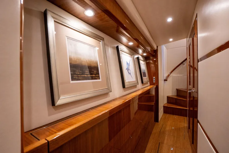 Galati Yacht Sales Trade Yacht Photos Pics Luxurious interior hallway of 2021 Viking 72 Enclosed Bridge yacht with framed artwork.