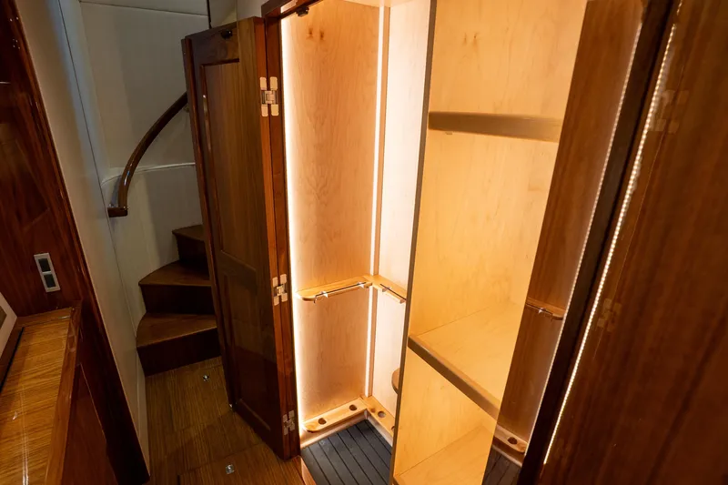 Galati Yacht Sales Trade Yacht Photos Pics Luxurious wooden interior of 2021 Viking 72 Enclosed Bridge yacht with illuminated closet.