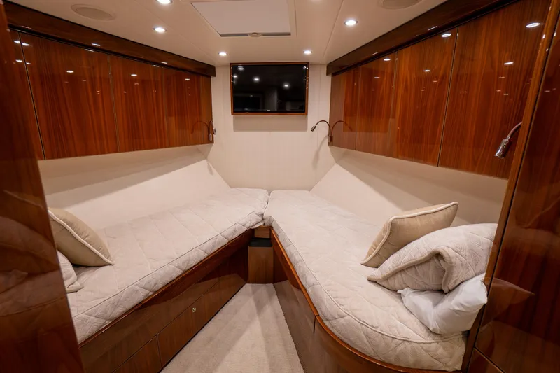 Galati Yacht Sales Trade Yacht Photos Pics Luxurious cabin interior of 2021 Viking 72 Enclosed Bridge yacht with twin beds and wood paneling.