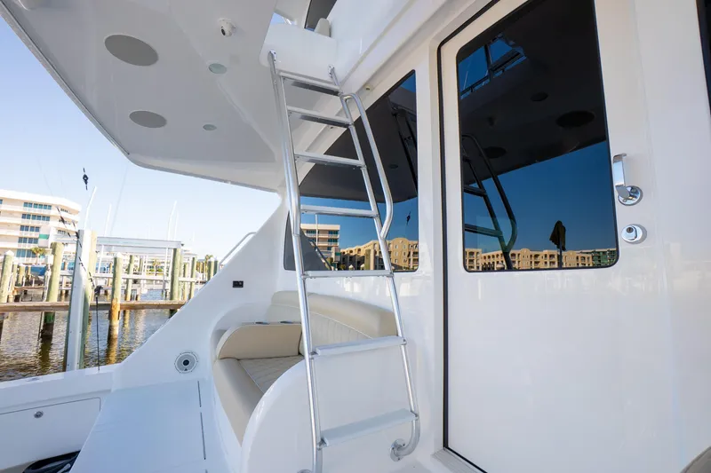 Galati Yacht Sales Trade Yacht Photos Pics 2021 Viking 72 Enclosed Bridge yacht with ladder and seating area at marina.