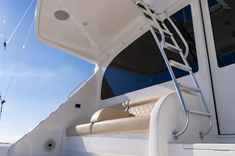 Galati Yacht Sales Trade Yacht Photos Pics 2021 Viking 72 Enclosed Bridge yacht with ladder and seating, under clear blue sky.