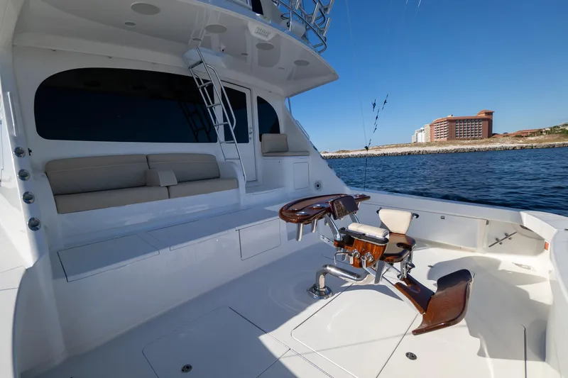 Galati Yacht Sales Trade Yacht Photos Pics 2021 Viking 72 Enclosed Bridge yacht with spacious deck and fishing chair, near coastal buildings.