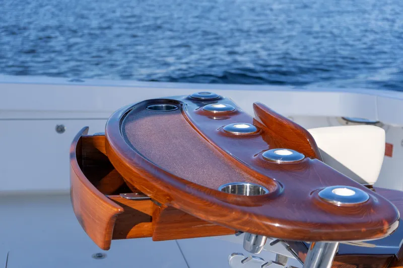 Galati Yacht Sales Trade Yacht Photos Pics Luxurious wooden fishing station on 2021 Viking 72 Enclosed Bridge yacht, with ocean backdrop.