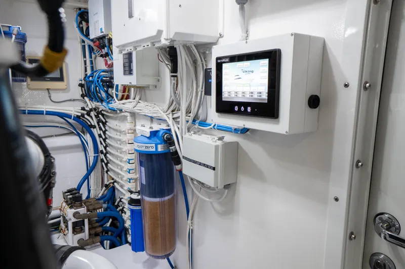 Galati Yacht Sales Trade Yacht Photos Pics Engine room of 2021 Viking 72 Enclosed Bridge yacht with control panel and wiring.